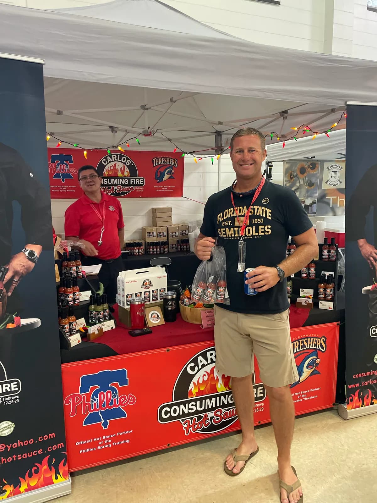 Customer with a bagged gift basket of sauces at an indoor market booth