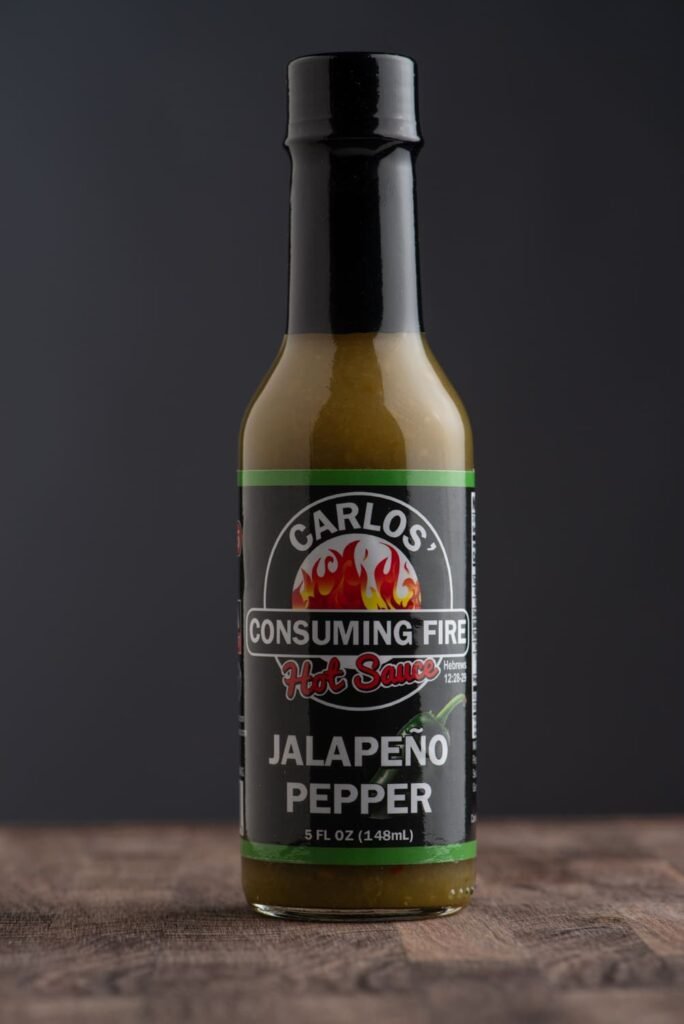 Front label of Carlos' Consuming Fire Hot Sauce Jalapeño Pepper bottle, 5 FL OZ (148mL).