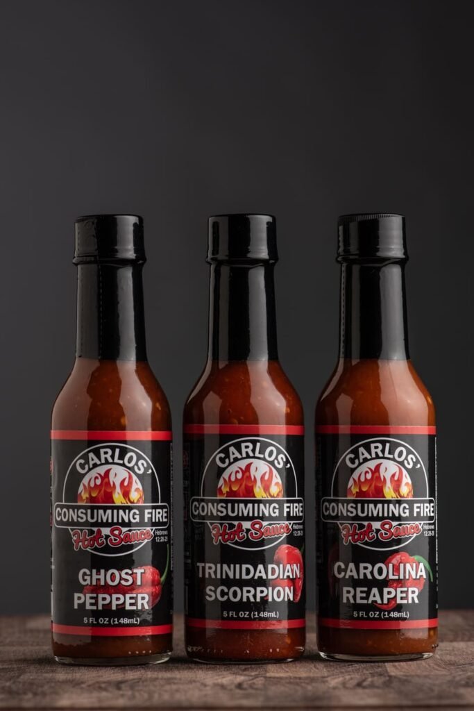 Triple Threat Bundle: Ghost Pepper, Trinidadian Scorpion, and Carolina Reaper on a dark studio background.