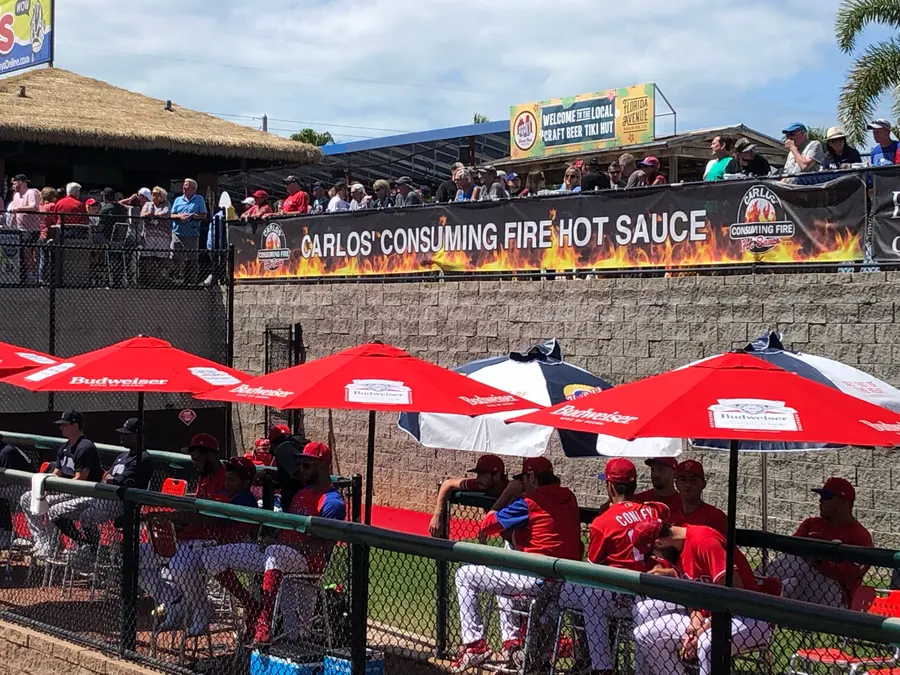 Carlos' Consuming Fire Hot Sauce banner on the outfield wall at BayCare Ballpark